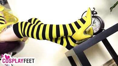 Cosplayer lility is wearing a yellow and black bee costume, with yellow high heels and striped socks