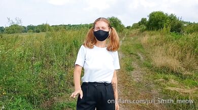 Bottomless girl with pigtails walks along a country road