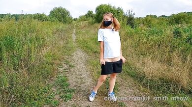 Bottomless girl with pigtails walks along a country road