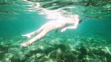 Naked girl dives in the ocean and shows her
