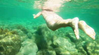 Naked girl dives in the ocean and shows her