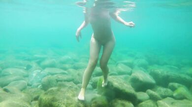 Naked girl dives in the ocean and shows her