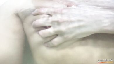 Boobs massage. A schoolgirl is playing with her boobs in the bathroom under the water