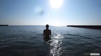Nude model swims on a public beach in Russia