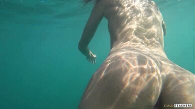 Nude model swims on a public beach in Russia