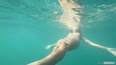Nude model swims on a public beach in Russia