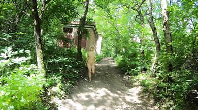 Naked girl walks along the street of old houses