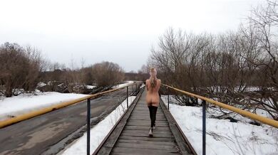 Naked girl walking on the bridge