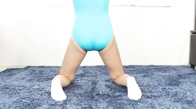 Rhythmic gymnastics stretching of a small woman in GKElite leotard excited by sexy yoga spandex,