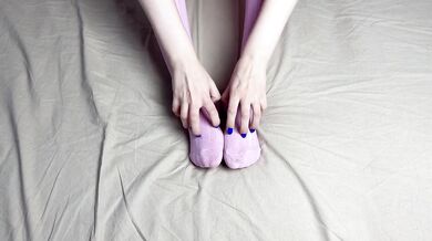 Pink socks in hands of mistress with blue nails in solo video