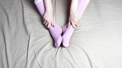 Pink socks in hands of mistress with blue nails in solo video