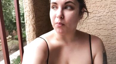 Smoking on balcony in a strappy top