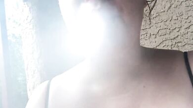 Smoking on balcony in a strappy top