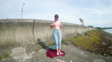 The girl undresses, walks and masturbates near the road by the lake