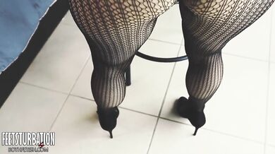 Shoe dangling with fishnets and black high heels