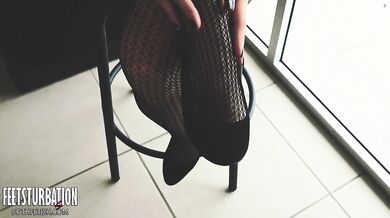 Shoe dangling with fishnets and black high heels
