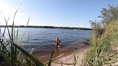 Fishermen swim past a beautiful nudist woman