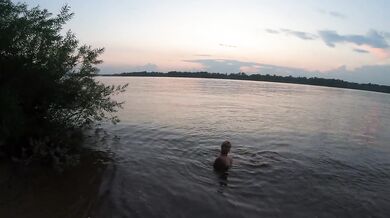 Fishermen swim past a beautiful nudist woman