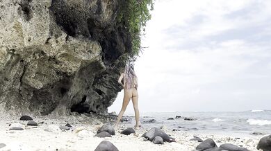 Undressing goddess on a hidden beach