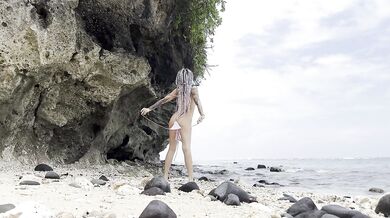 Undressing goddess on a hidden beach
