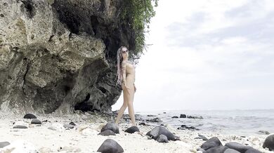 Undressing goddess on a hidden beach