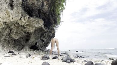 Undressing goddess on a hidden beach