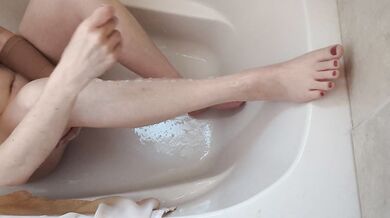 MILF shaving her legs sitting the the shower