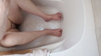 MILF shaving her legs sitting the the shower