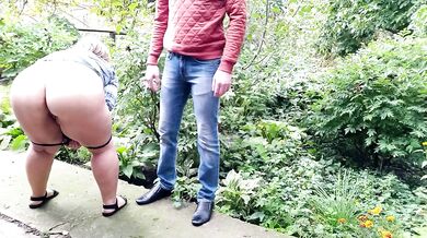 Mature milf holds a pissing stranger's cock
