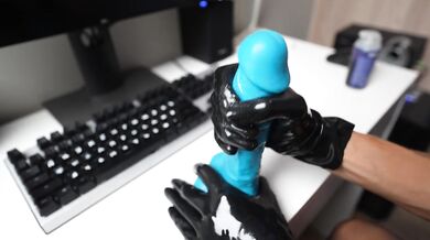 A gorgeous brunette in a red vinyl skirt and latex gloves masturbates a blue cock
