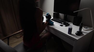 A gorgeous brunette in a red vinyl skirt and latex gloves masturbates a blue cock
