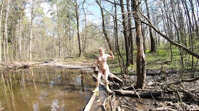 Naked girl crosses a puddle