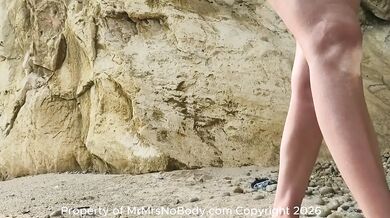 Naughty redhead flashes her pink pussy on the nude beach while strangers watch