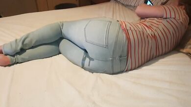 Girl wets her jeans on bed while playing with her phone desperate for pee