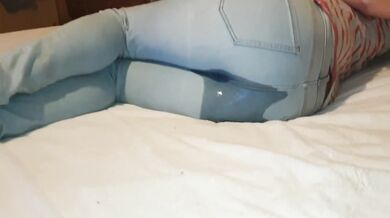 Girl wets her jeans on bed while playing with her phone desperate for pee