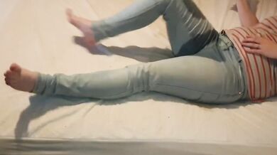 Girl wets her jeans on bed while playing with her phone desperate for pee