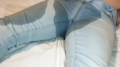 Girl wets her jeans on bed while playing with her phone desperate for pee