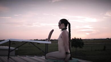 Cuffed creature chokes massive dildo at sunset