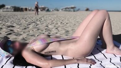 Exposed in a slingshot bikini on the public beach her tits popping out
