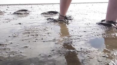 Feet in fine stockings splashing the Wadden Sea Wangerland