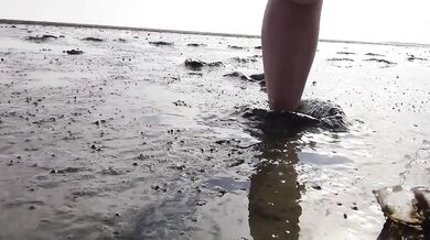Feet in fine stockings splashing the Wadden Sea Wangerland