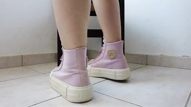 Showing off pink Converse sneakers and white ankle socks