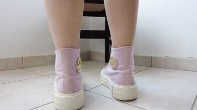 Showing off pink Converse sneakers and white ankle socks