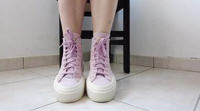 Showing off pink Converse sneakers and white ankle socks