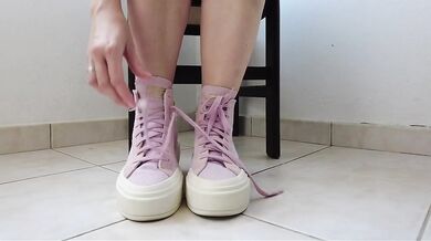 Showing off pink Converse sneakers and white ankle socks