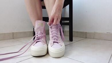 Showing off pink Converse sneakers and white ankle socks