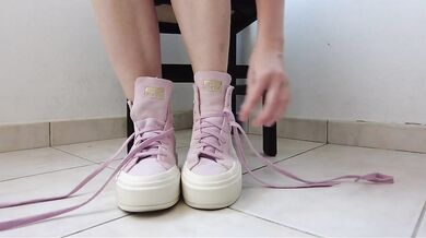 Showing off pink Converse sneakers and white ankle socks