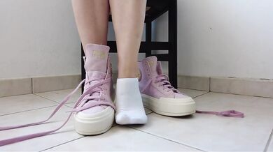 Showing off pink Converse sneakers and white ankle socks
