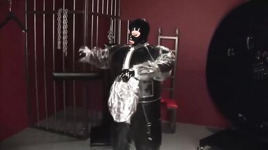 Blonde girl in black latex catsuit full encased in inflatable rubber and full body plastic suit