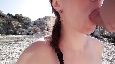 Brunette sucks a stranger's cock on a wild beach and swallows his cum